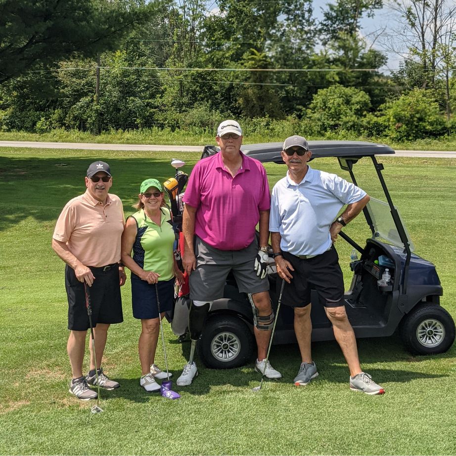 golf scramble team in front of cart